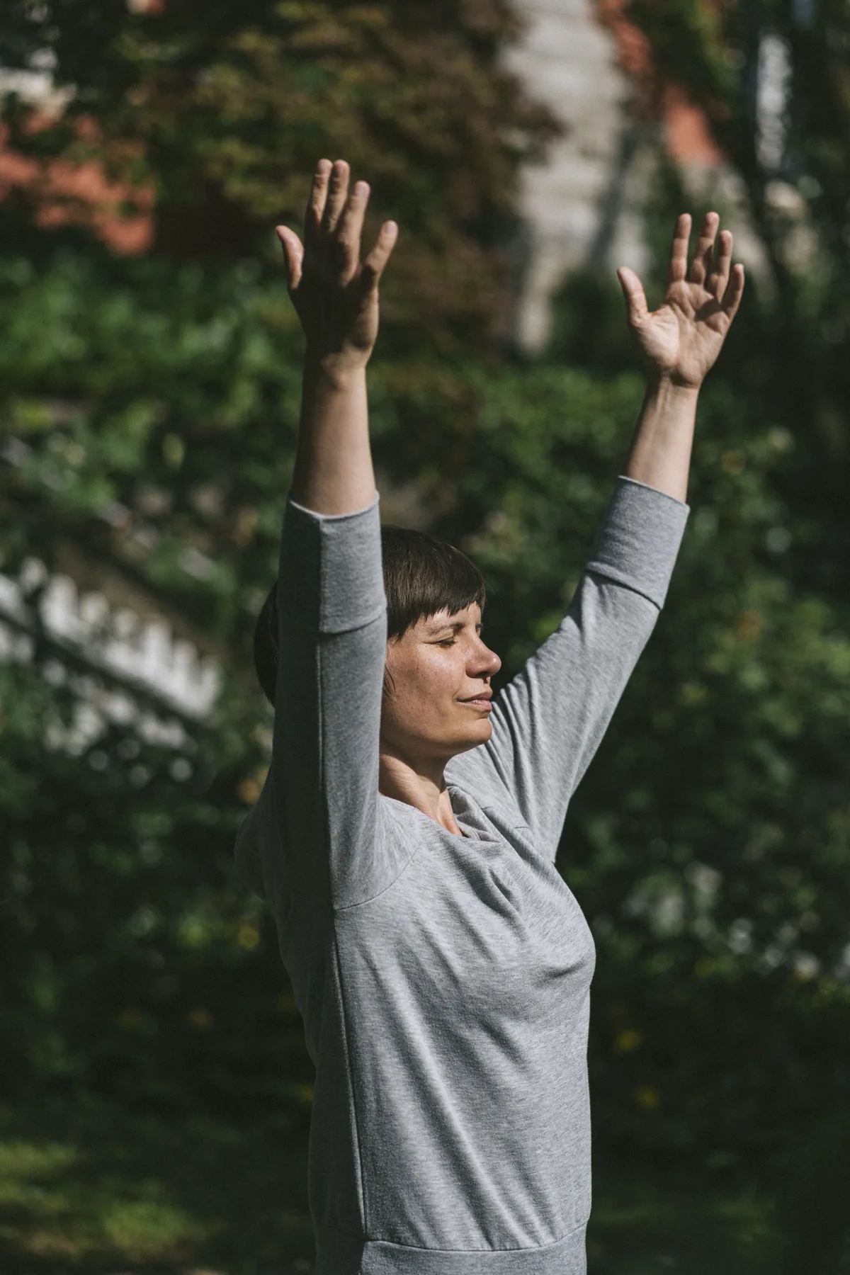 Julia Badum mit erhobenen Armen bei einer bewegten Meditation
