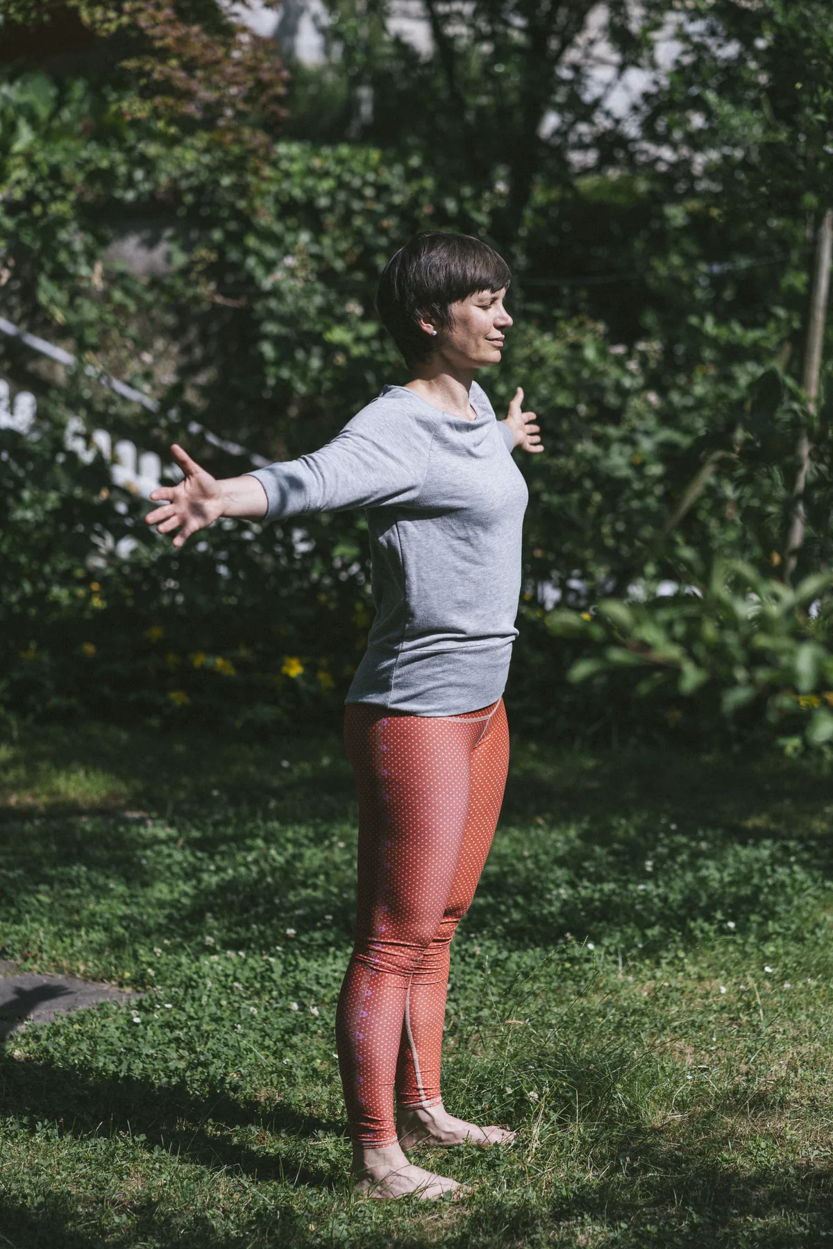 Julia Badum steht mit geöffneten Armen im Garten