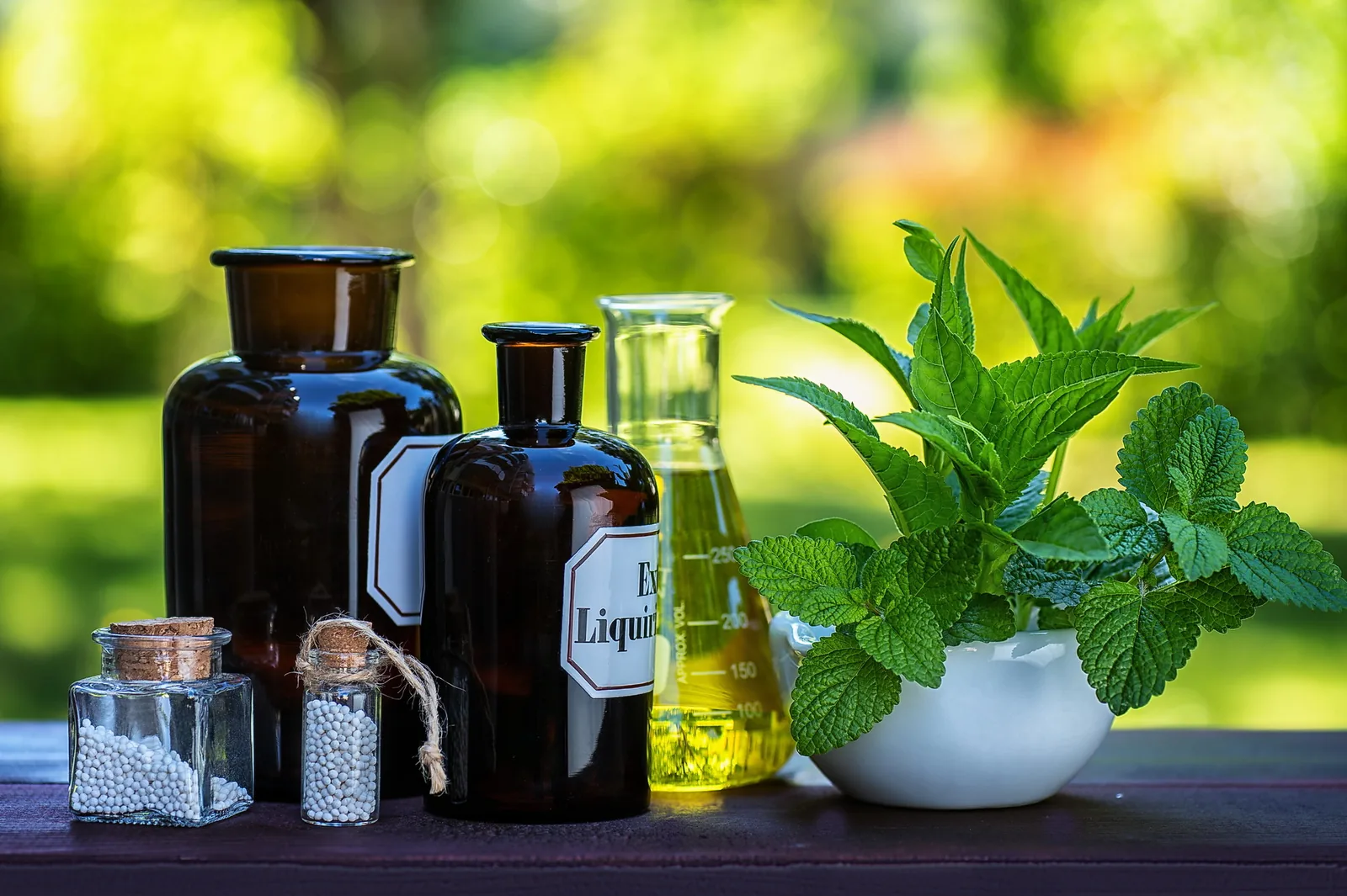 Apothekerflaschen und frische Kräuter